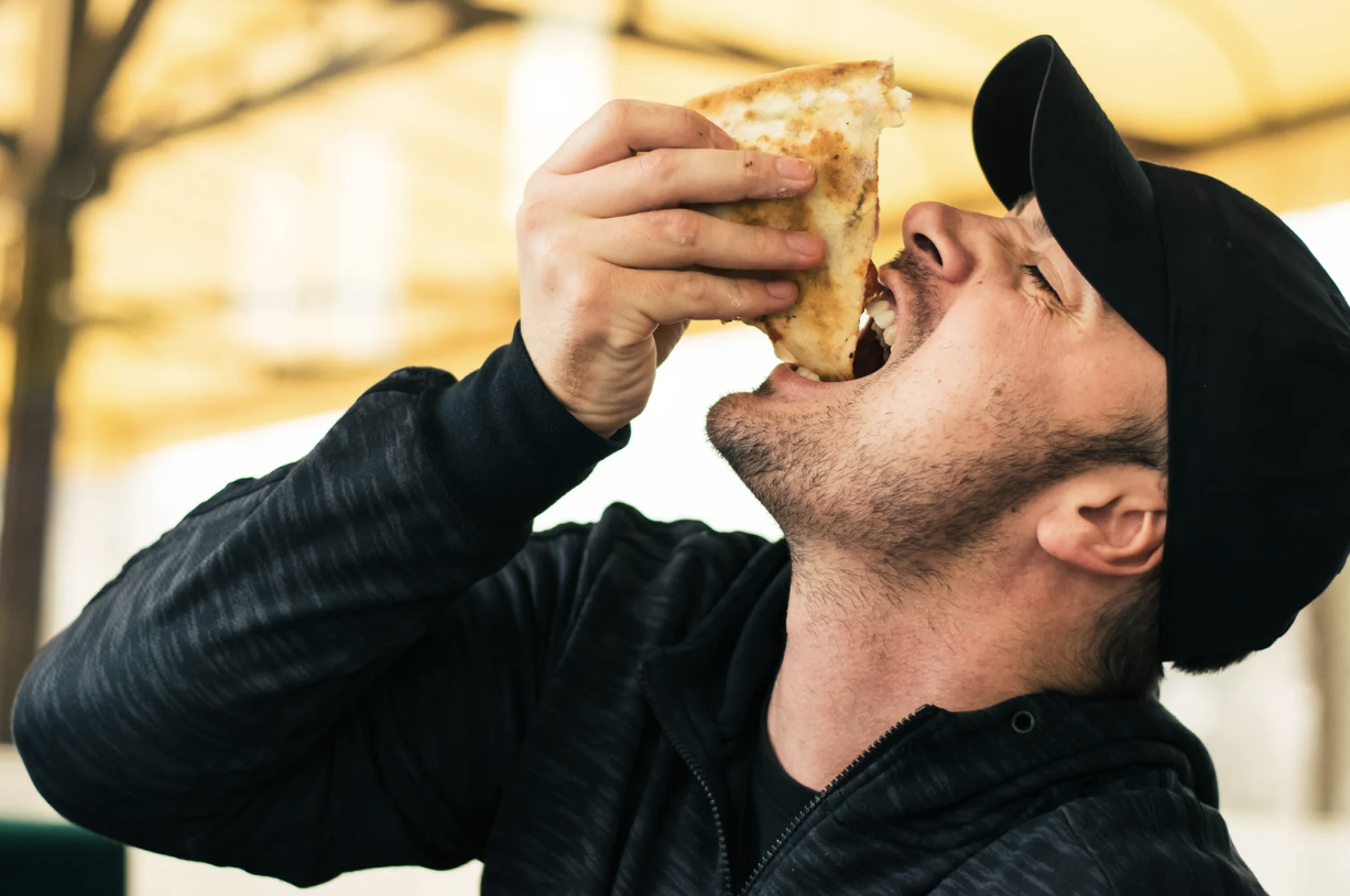 A person eating a slice of pizza