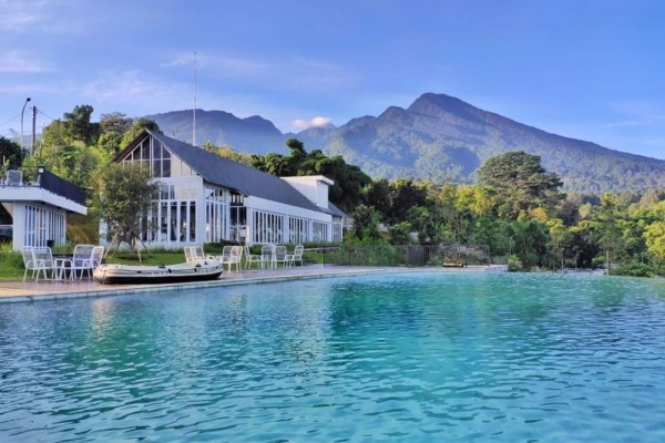 pemandangan dari birunya air di kolam renang leuweung geledegan ecolodge berlatarkan hijaunya pegunungan