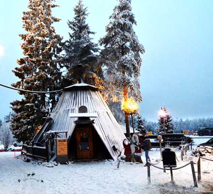 Santa's Salmon tent inside Santa's Village. In the background three large trees covered in snow.