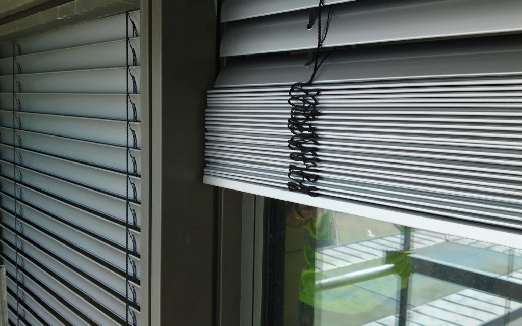 Folded Venetian blinds hanging in the window