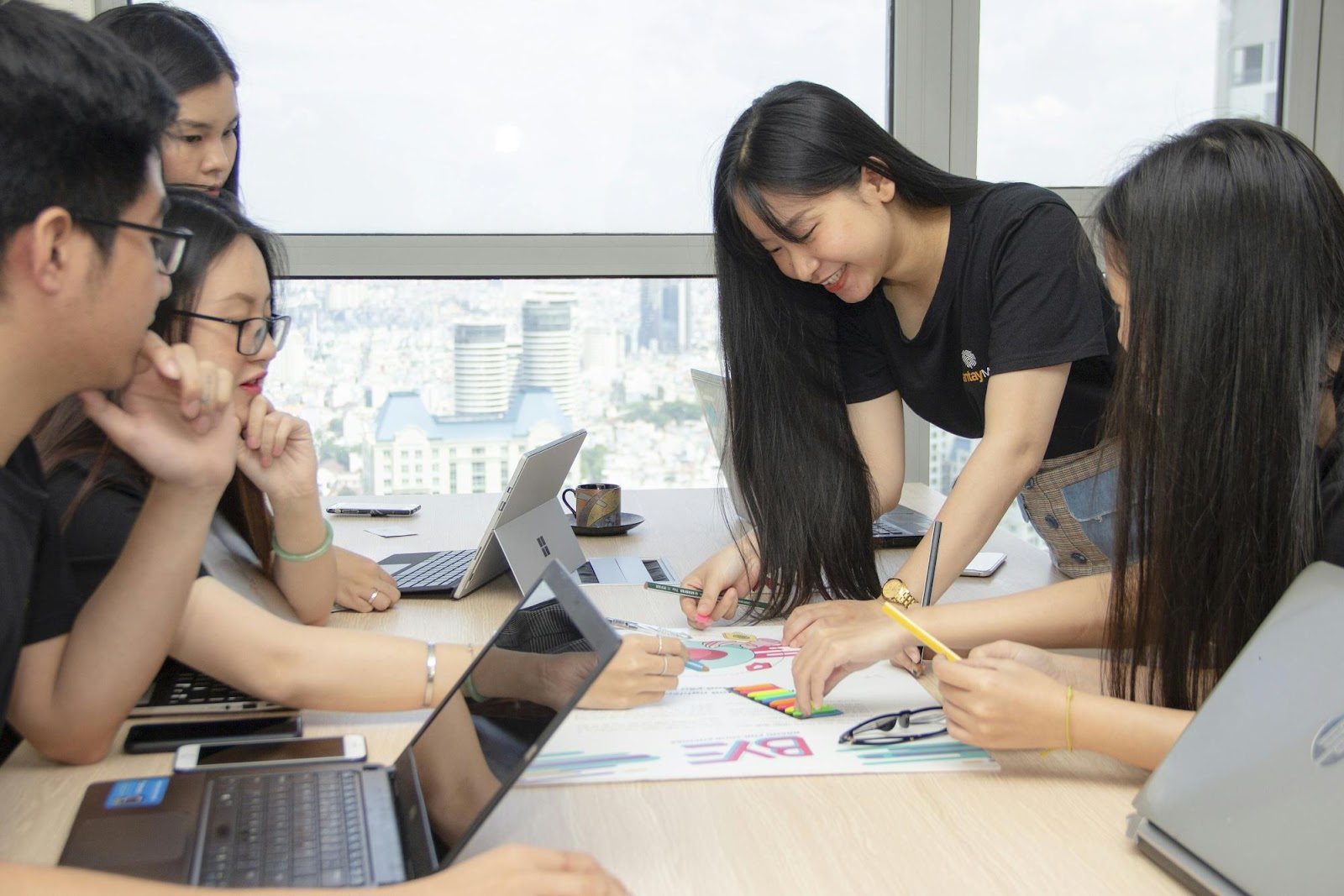 a group of people sitting at a table looking at a paper