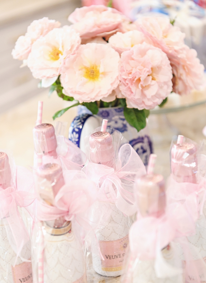 champagne with straws in front of pink flowers