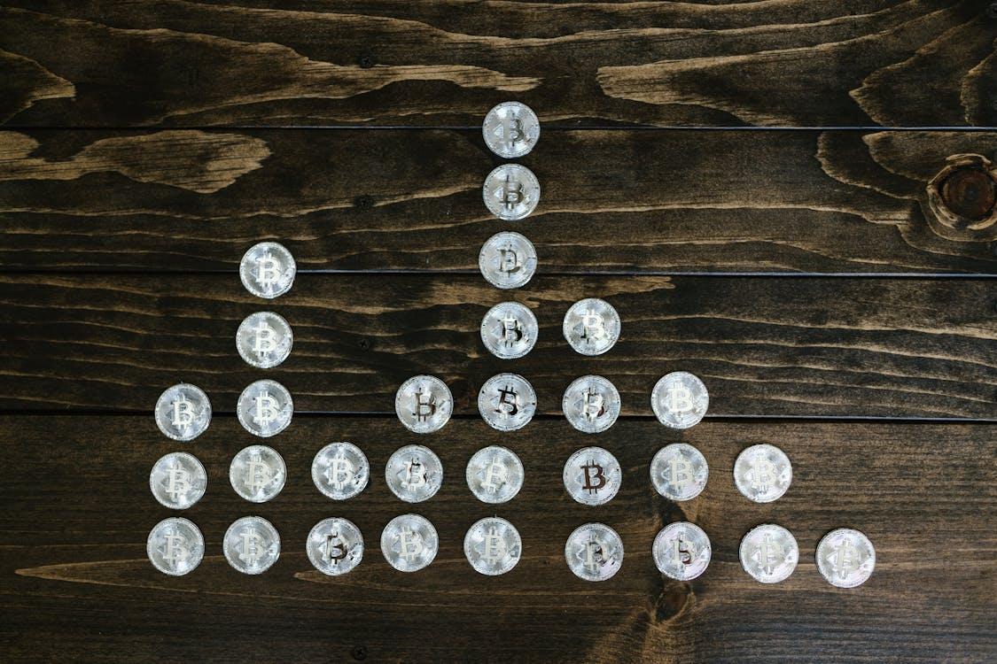 Free Silver Round Coins on Brown Wooden Surface Stock Photo