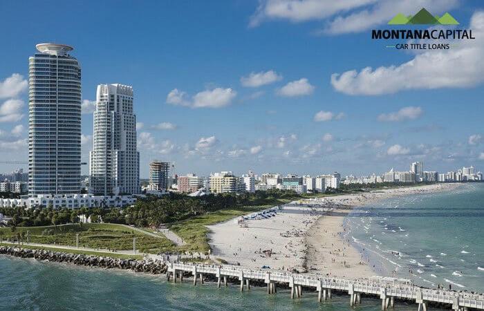 A beach with a pier and buildings

Description automatically generated