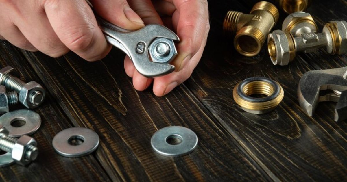 Person tightening nut with wrench.