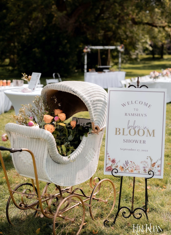 baby carriage with flowers and baby in bloom sign