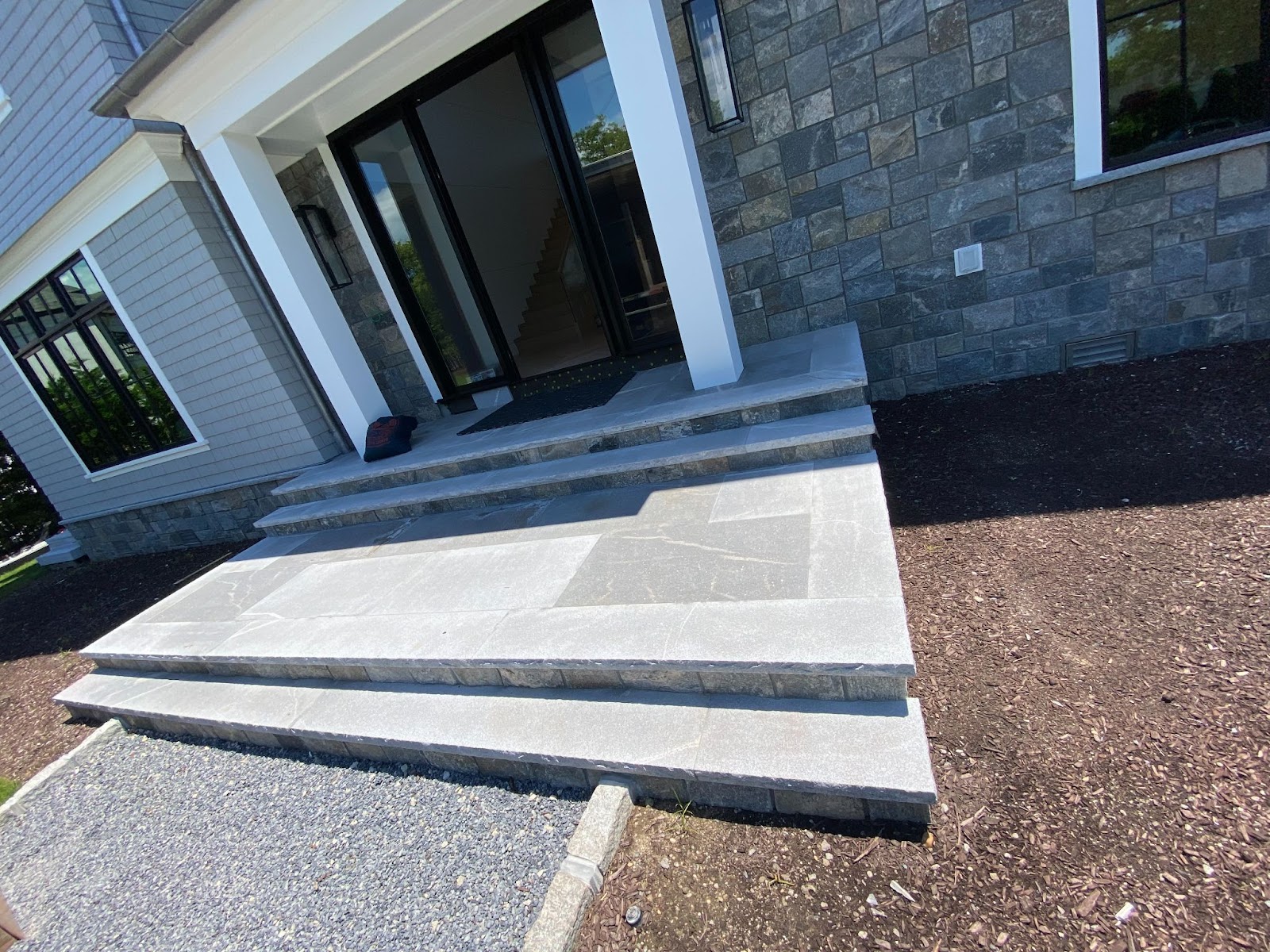 Front of new home build with natural stone entryway and natural stone siding