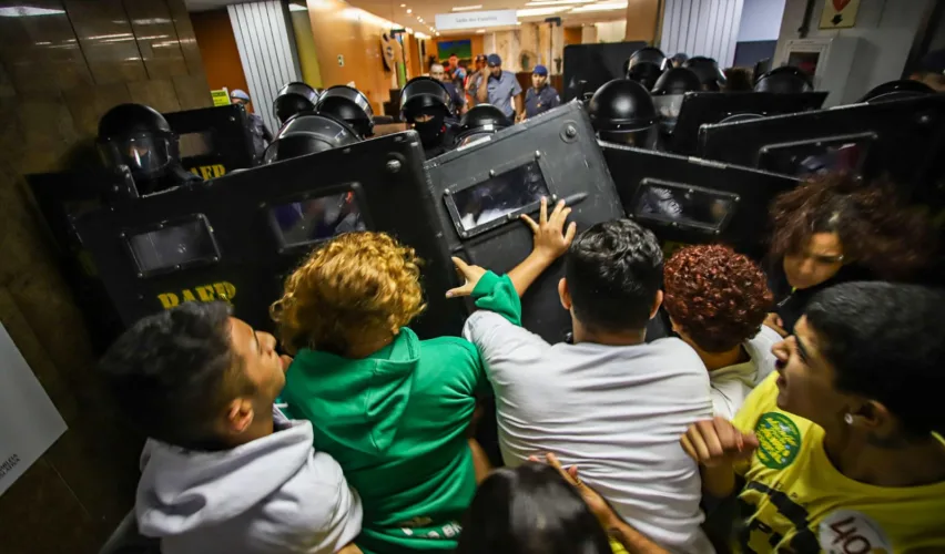 Jovens são empurrados por escudos de oficiais durante protesto na Alesp