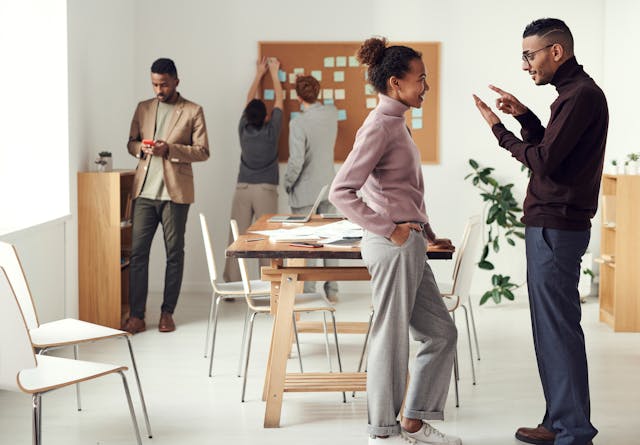 A group of professionals in an office setting with a banner reading "how to make your team work better.