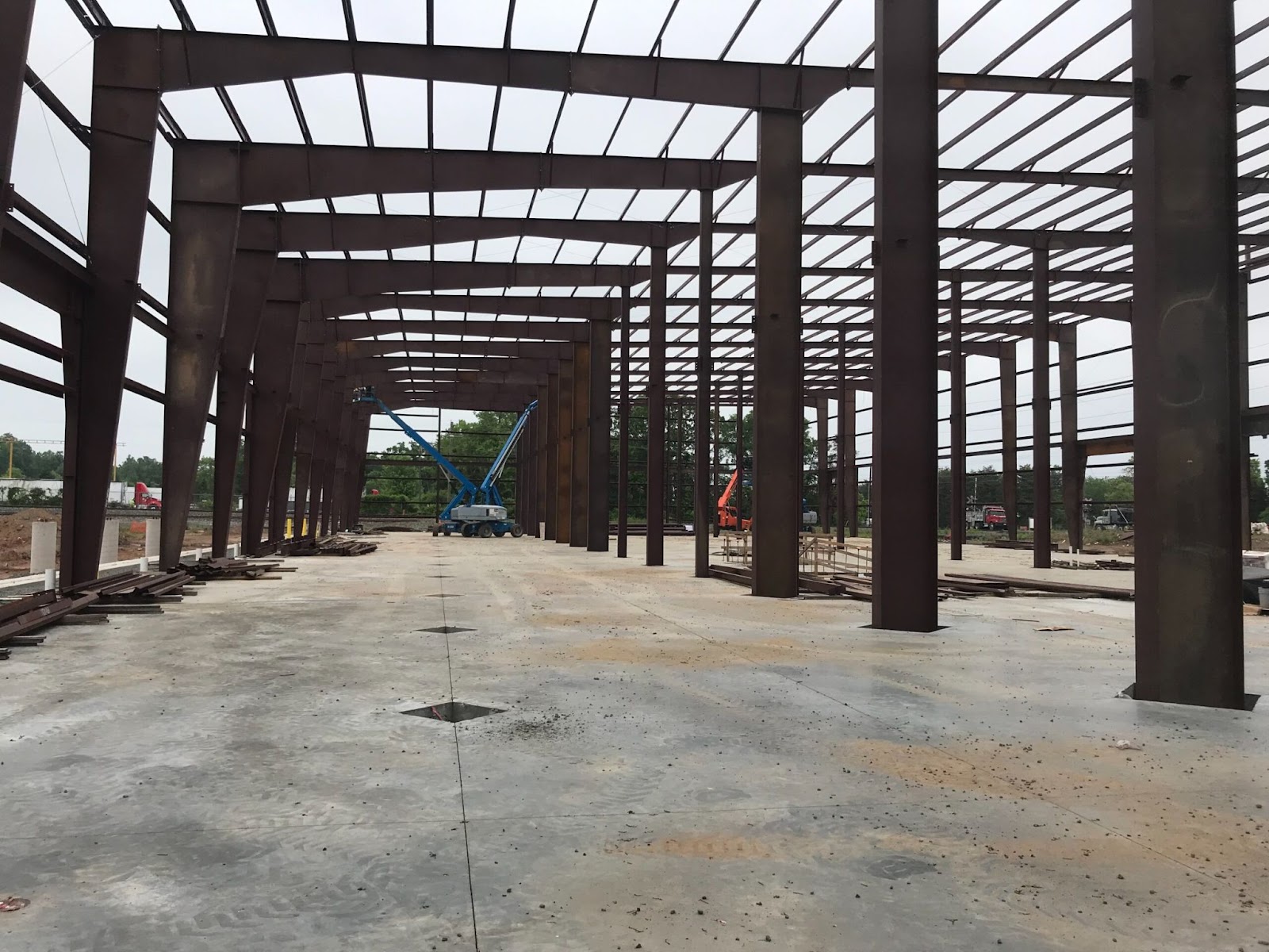 An under-construction Dalitso Cannabis Processing Facility with visible steel columns and beams forming the skeletal structure. Construction equipment and materials are scattered on the concrete floor.