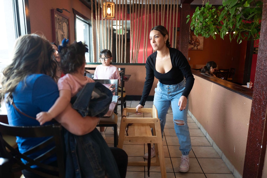 Hostess provides high chair at a restaurant