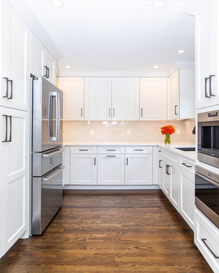 A kitchen with white cabinets and stainless steel appliances

Description automatically generated