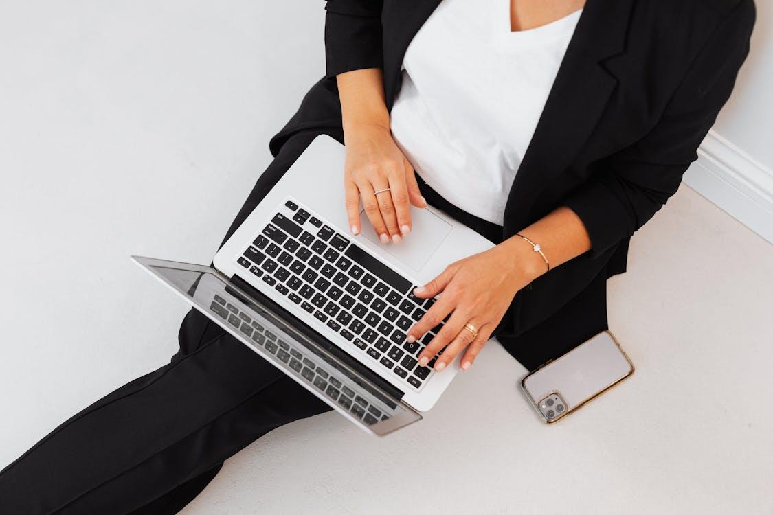 Free A Person in Black Blazer Sitting on the Floor while Using MacBook  Stock Photo