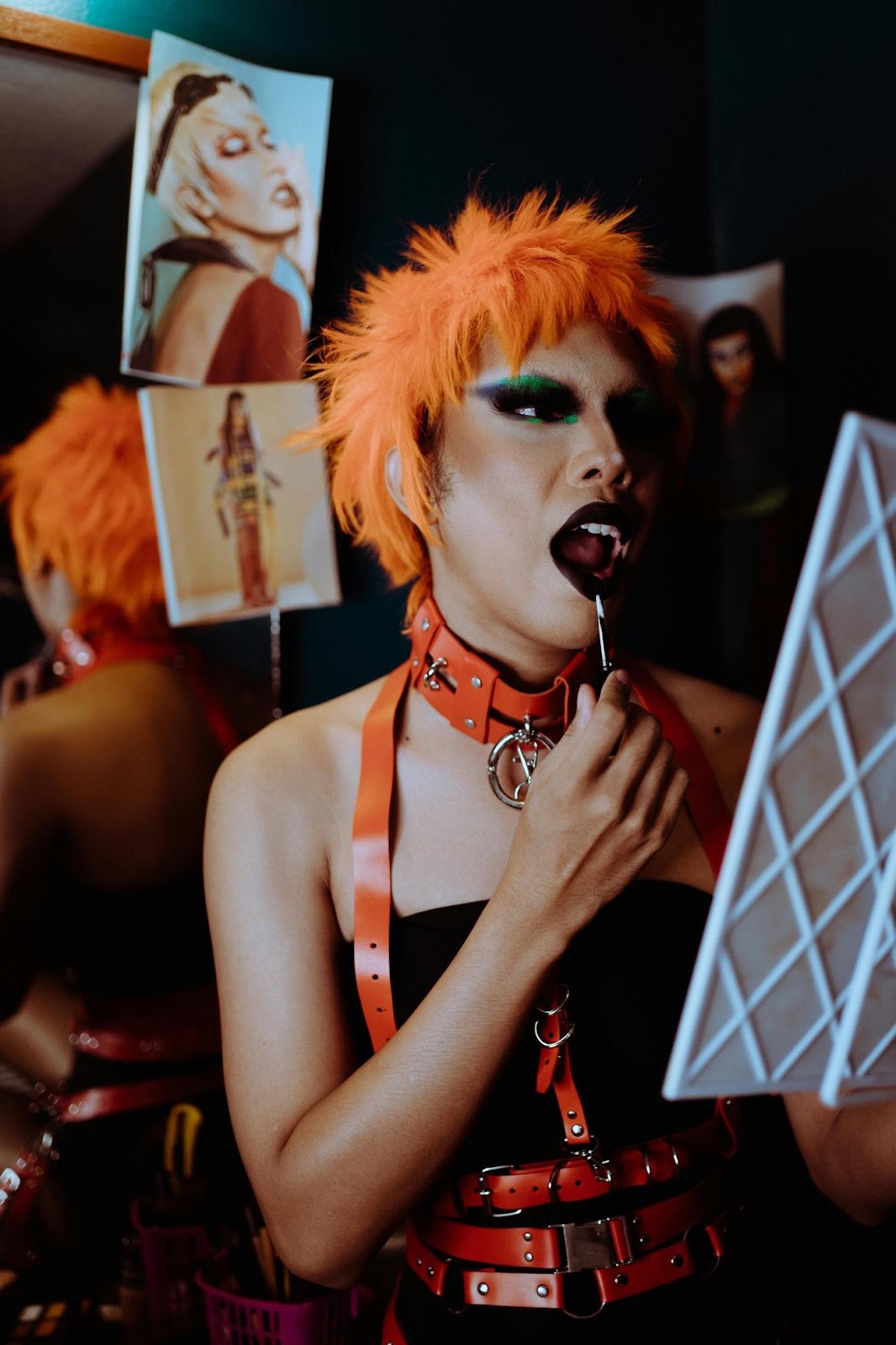 A person with orange hair and black makeup

Description automatically generated