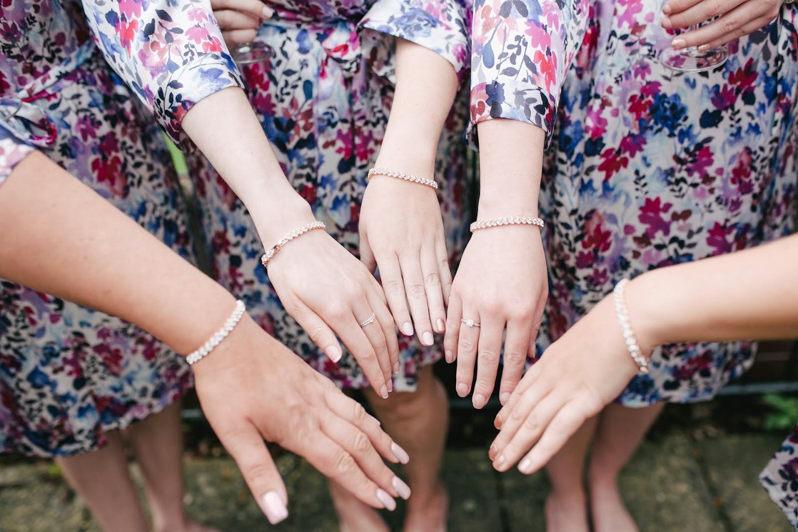 Bridesmaids in matching dresses showing off their bracelets.
Matching jewelry can make a great bridesmaid gift if you want them all to wear it on the wedding day.
  