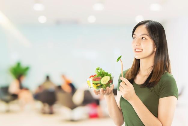 Free photo happy lady holding kitchen stuff over copy space background