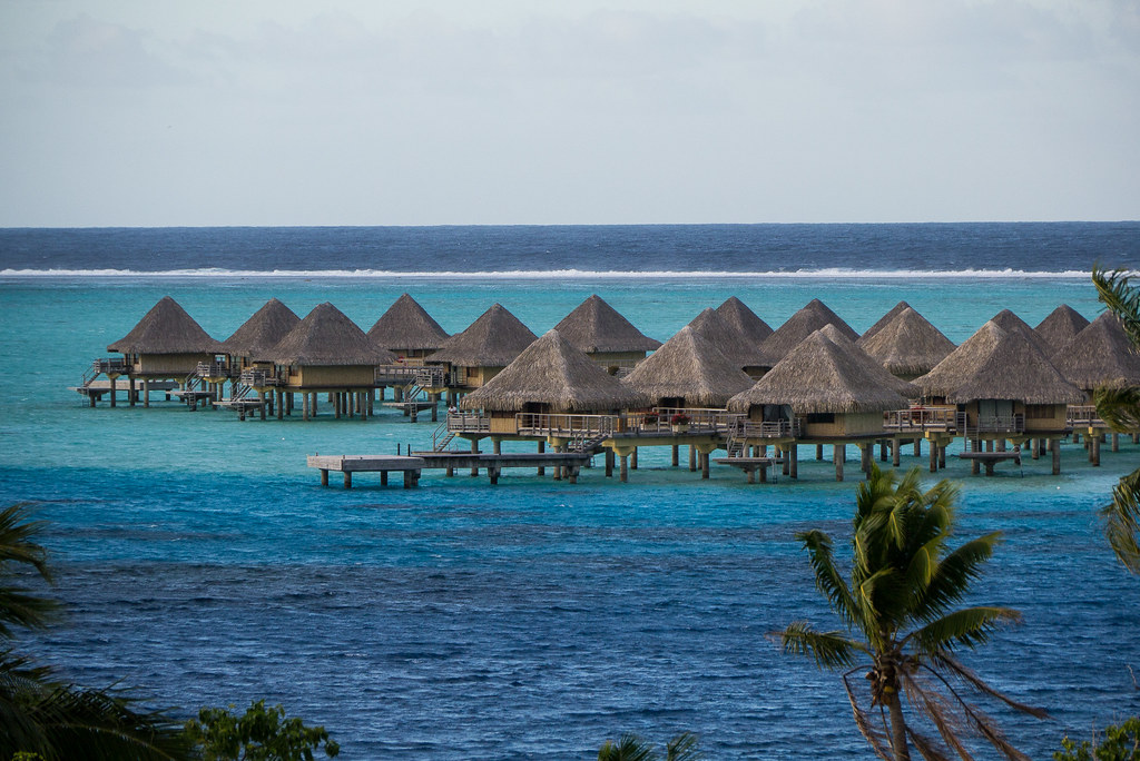 Clear blue water with water huts situated over the water.