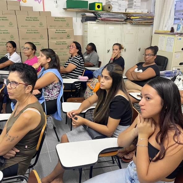 Grupo de pessoas sentadas ao redor de um computador

Descrição gerada automaticamente