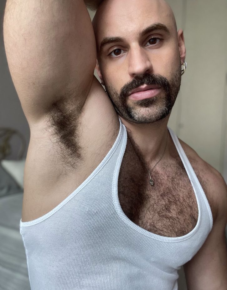 Mister Caccamo showing off his armpit hair for gay armpit fetish onlyfans content while wearing a white ribbed tank top