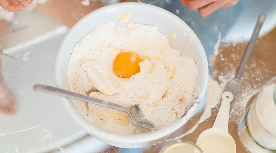 Oeuf dans un mélange de farine avec des ustensiles de cuisine