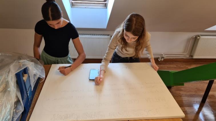 Two girls standing at a table

Description automatically generated