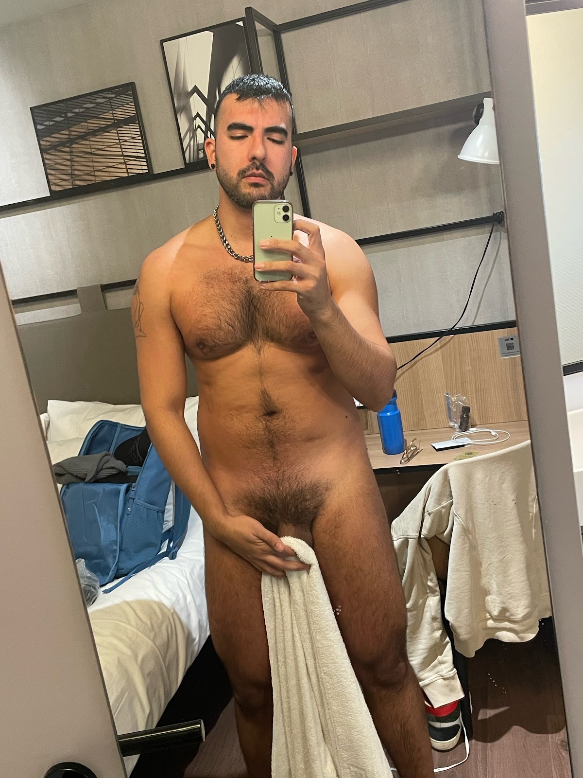 gay xxx porn creator Phil naked holding a towel over his flaccid cock in paris hotel room taking an iphone mirror selfie
