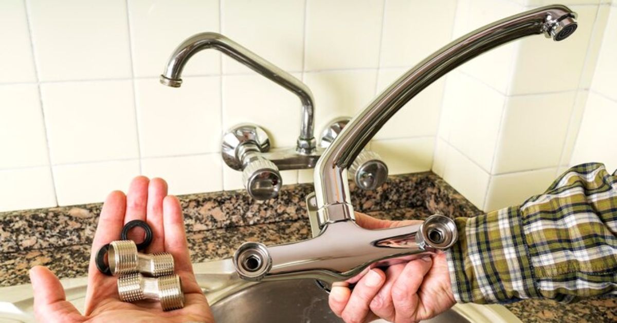 Person holding faucet with rubber ring for Tightening Loose Moen Kitchen Faucet Handle