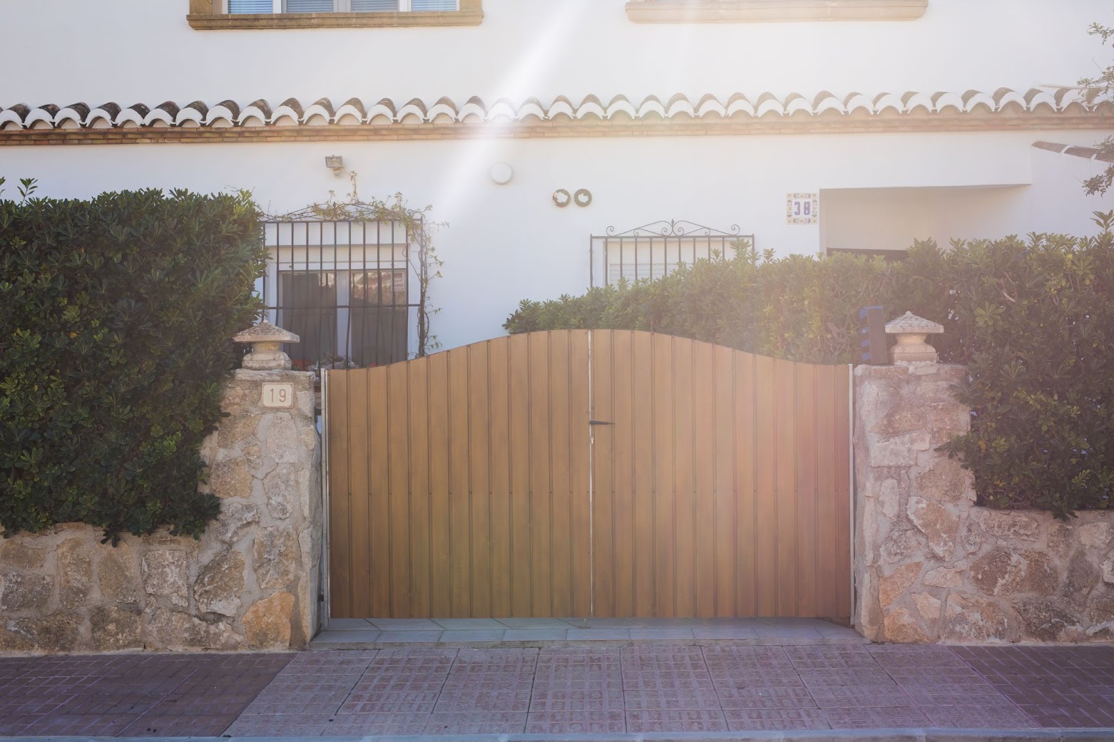 Wooden gate next to shrubbery. 