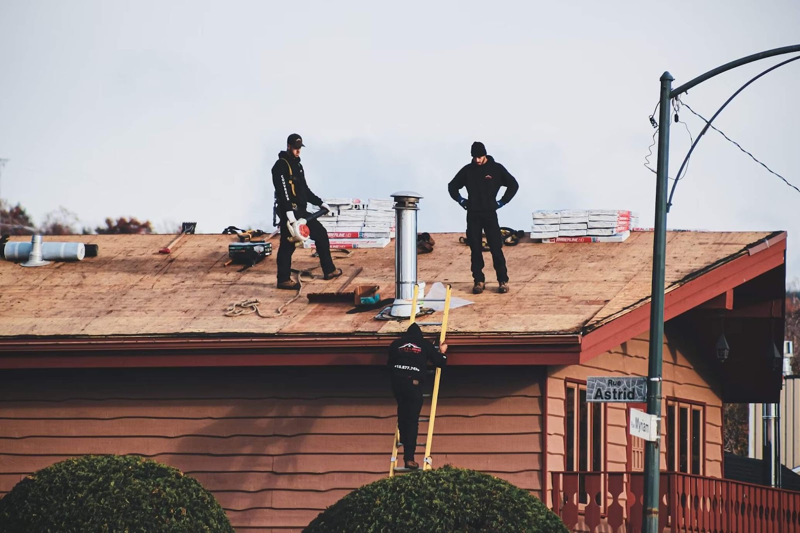 Roofers equipped with professional working tools, repairing a commercial roof.