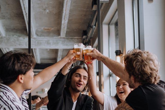 A group of people celebrating, lifting and clinking their glasses in the air