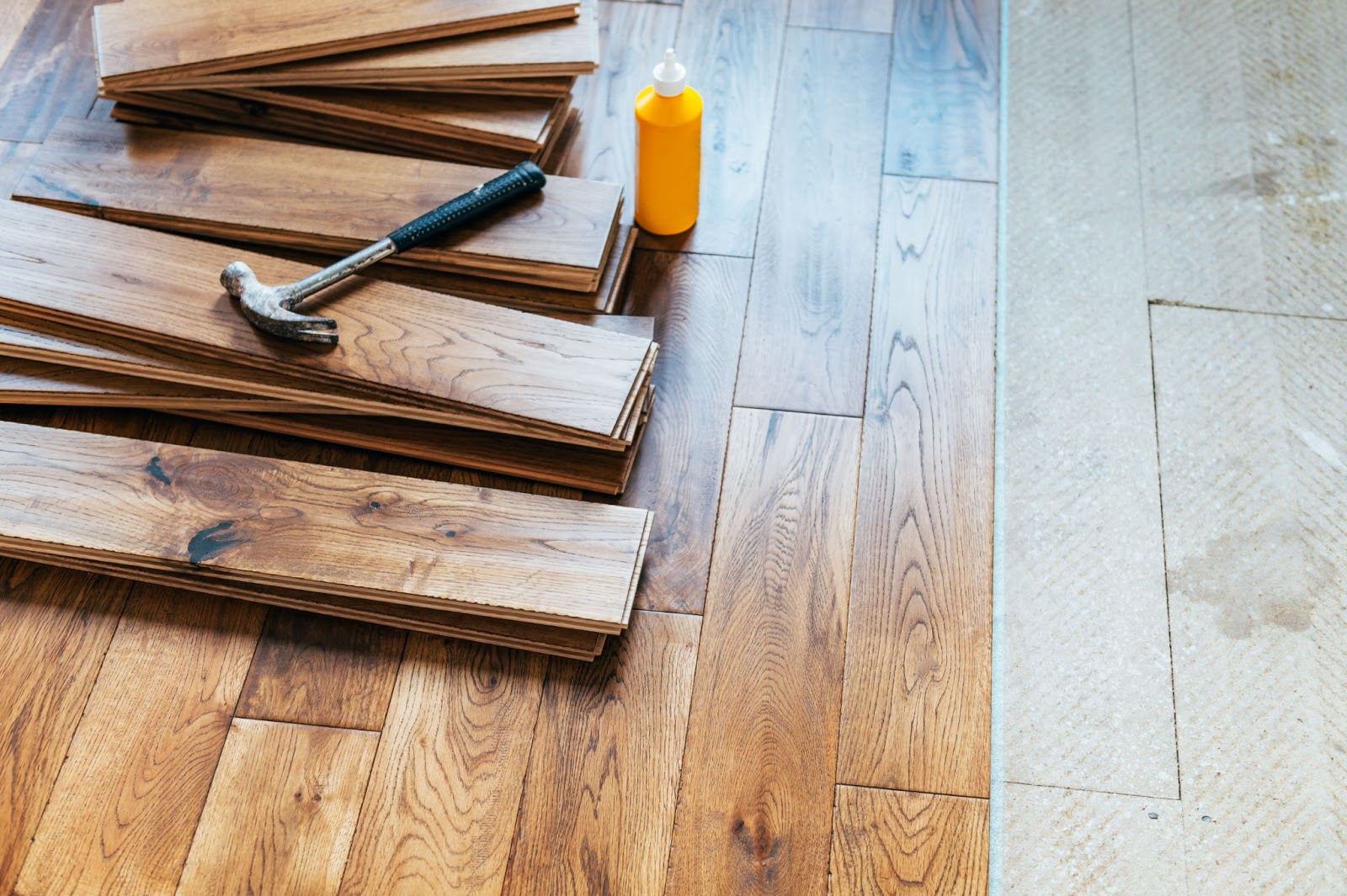 Oakwood flooring and a hammer laying on top of boards.