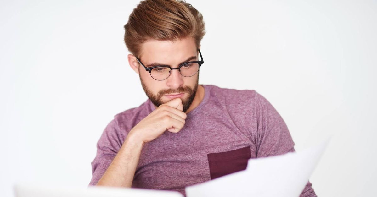 man studying information on paper