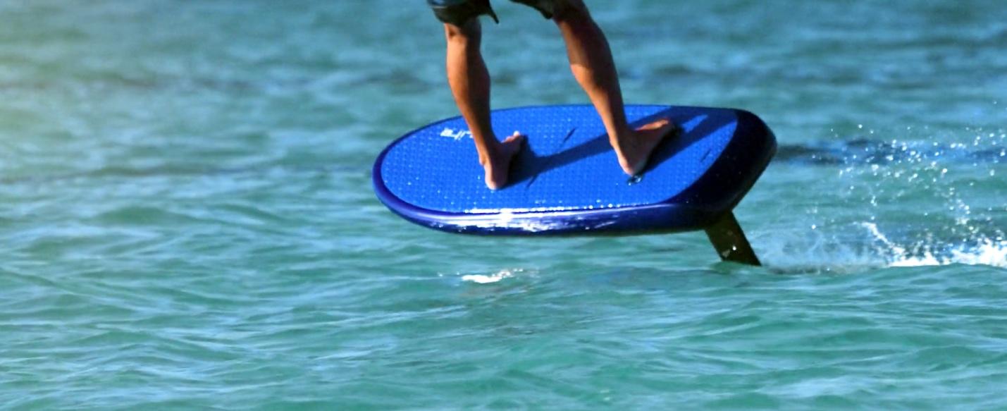 A person on a blue surfboard

Description automatically generated