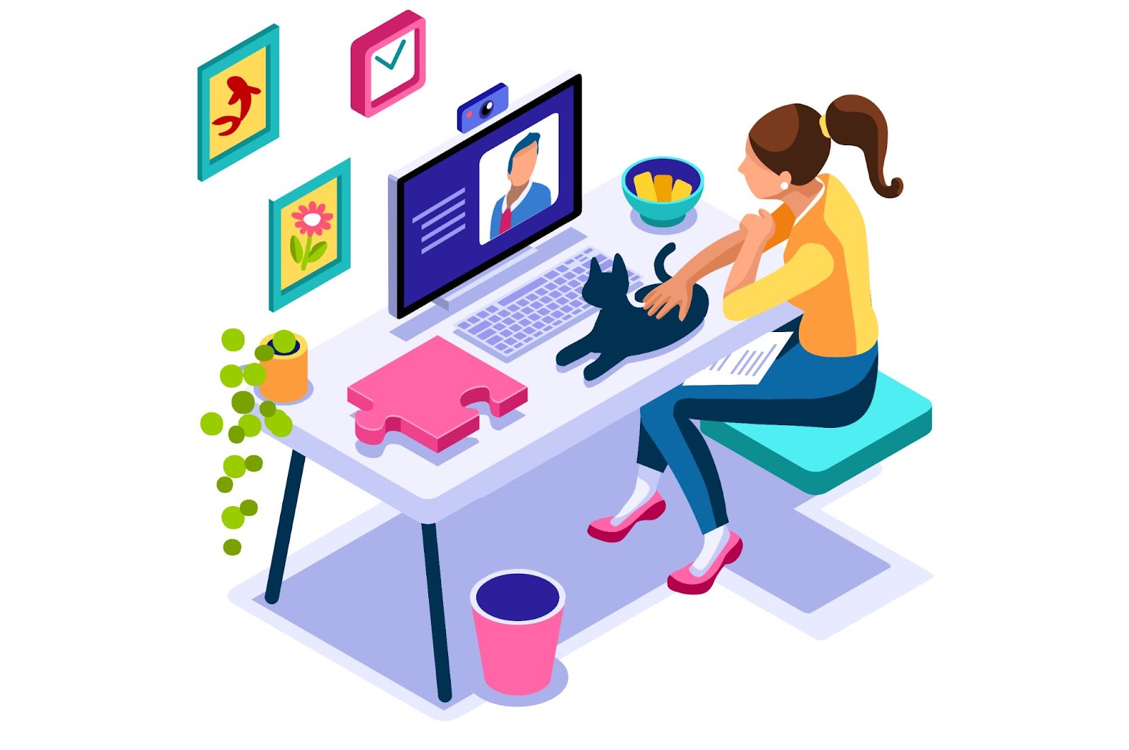 A girl sits at a desk in front of a computer screen with a video call in progress, showing her cat to the person in the video call while petting the black feline. The desk also has a plant, puzzle pieces, and a bowl of snacks, and it is decorated with pictures.