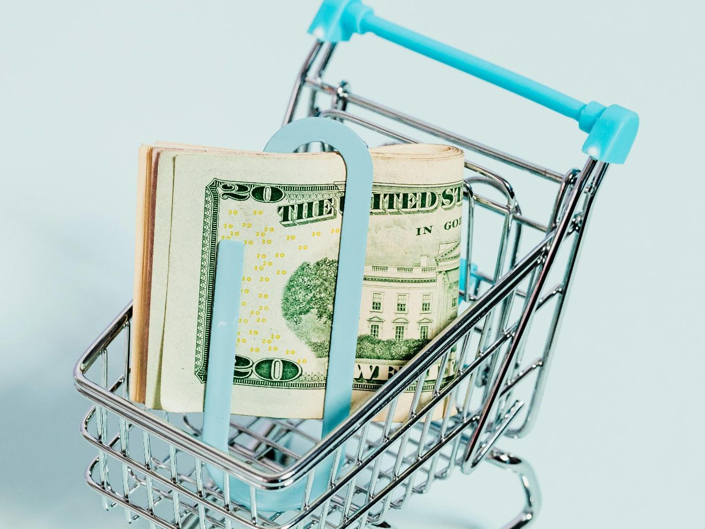 A shopping cart full of money Description automatically generated