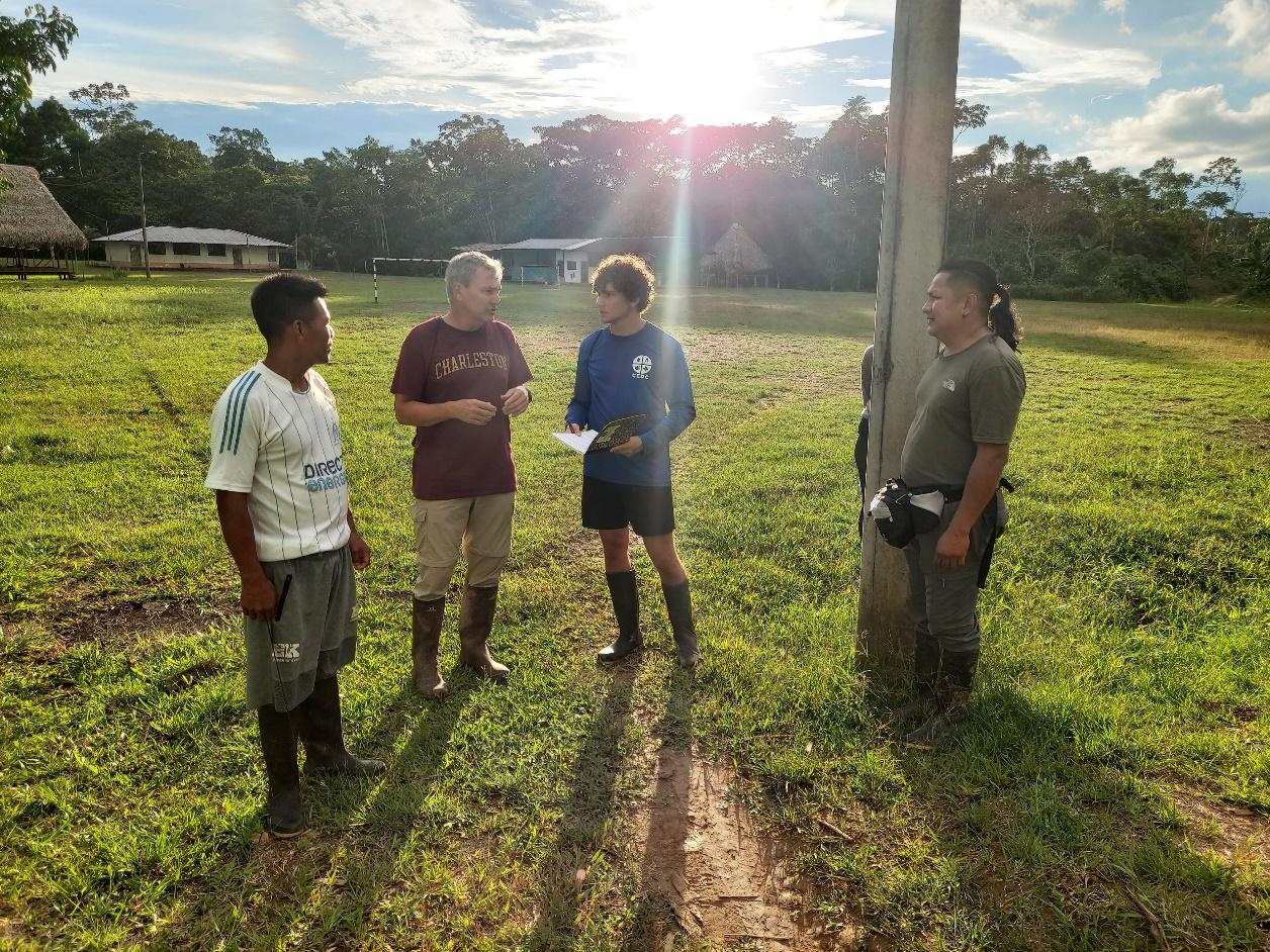 A group of men standing in a field

Description automatically generated