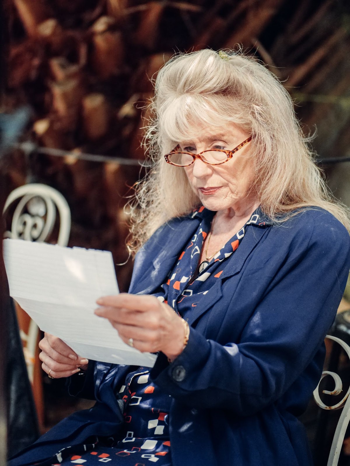 A senior citizen looking at a paper on a bench as if considering the costs of in-home dementia care