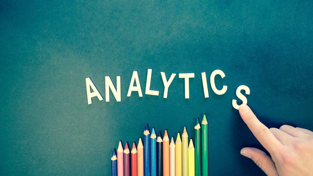 Letting spelling out the word analytics next to colored pencils
