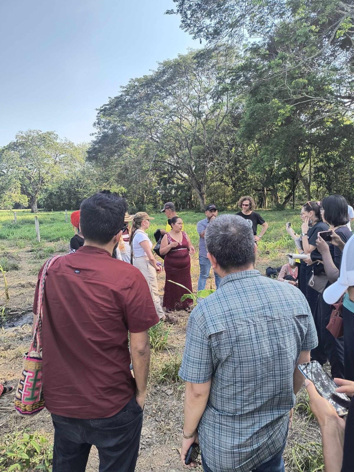 A group of people standing in a field

Description automatically generated