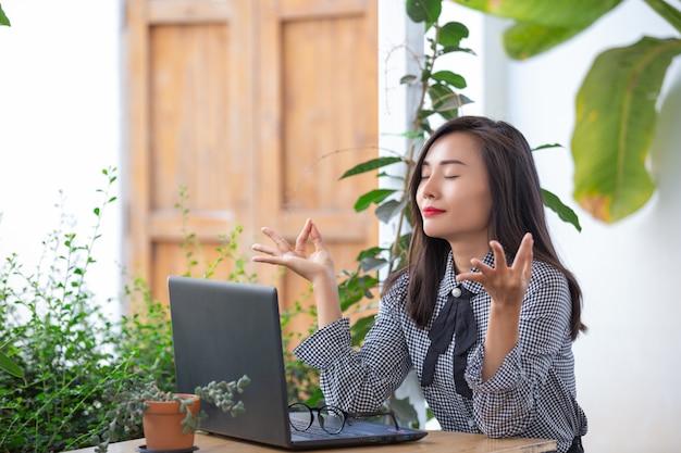 Free photo smiling businesswoman shows gestures to meditate