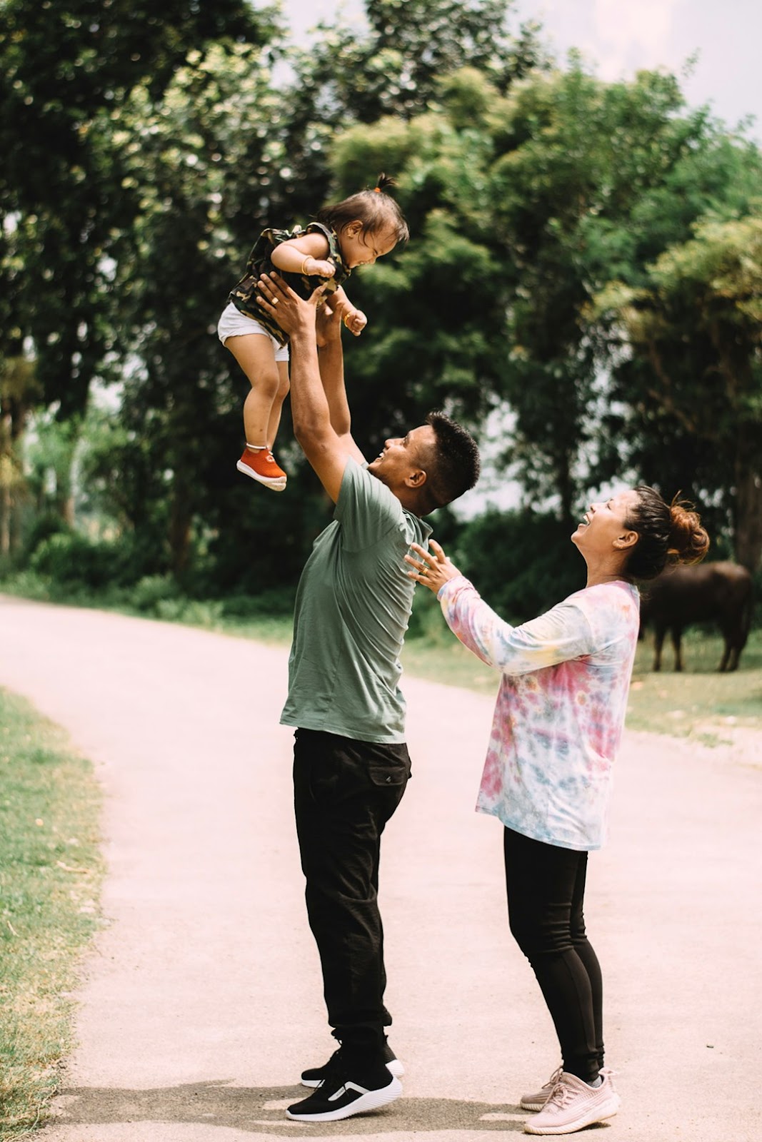 man in white t-shirt carrying girl in pink dress