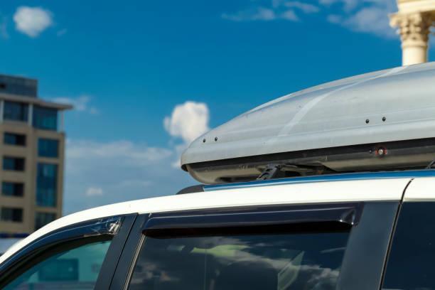 Vintage suitcases on the roof of the trunk of a car. Vintage suitcases on the roof of the trunk of a car. R1S Roof Rack stock pictures, royalty-free photos & images