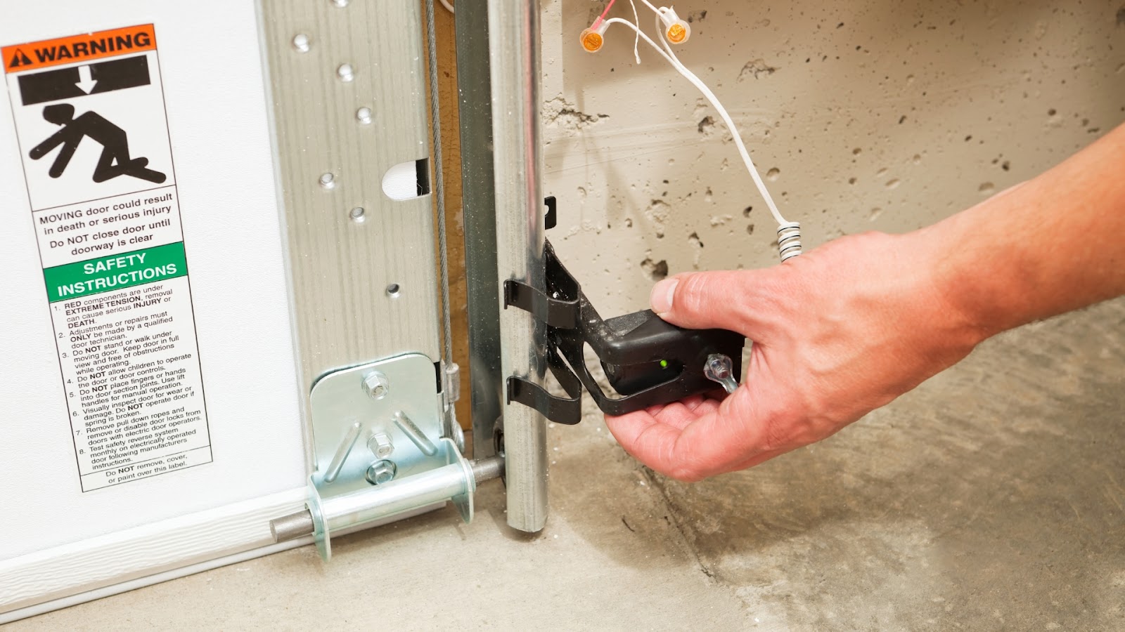A garage door technician adjusting the safety sensors