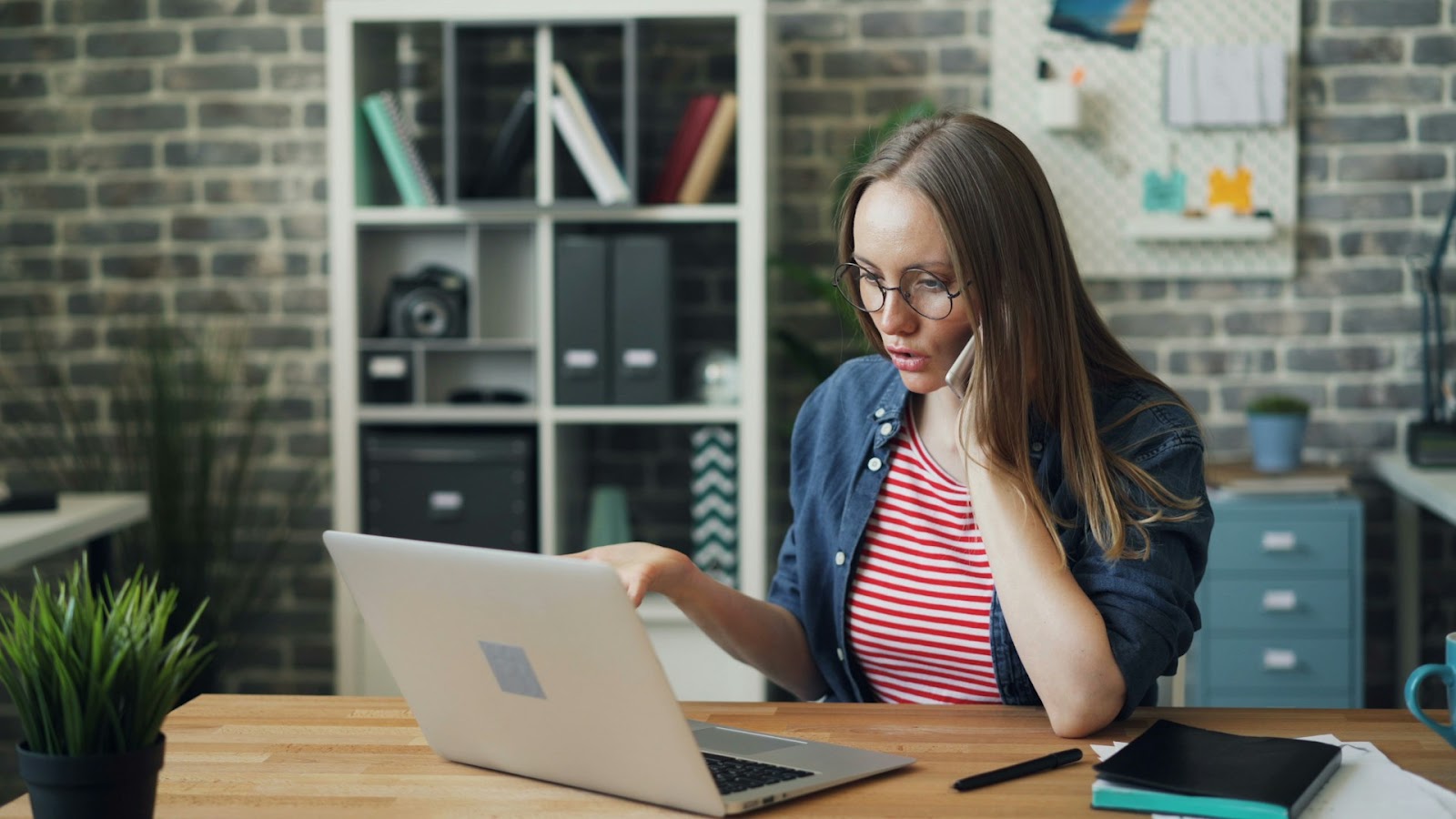 A woman using a laptop at a table in a home setting.