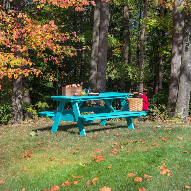 A bright blue-green recycled plastic picnic table sits in a park