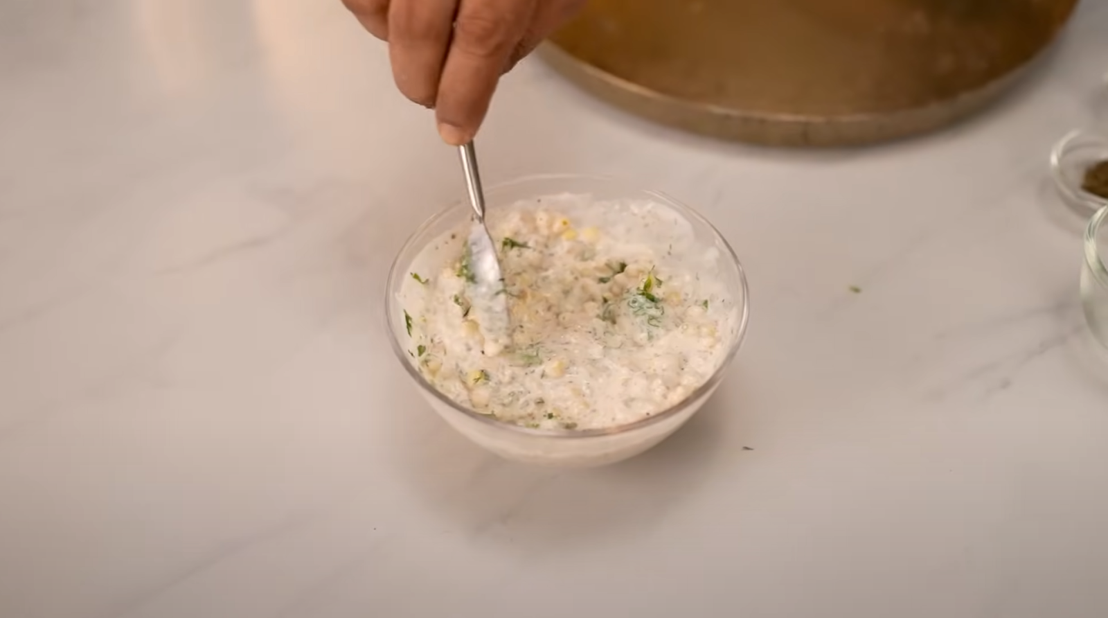 A bowl of raita garnished with roasted cumin powder and boondi, ready to be served.