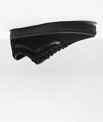 A black shoe on a white surface

Description automatically generated
