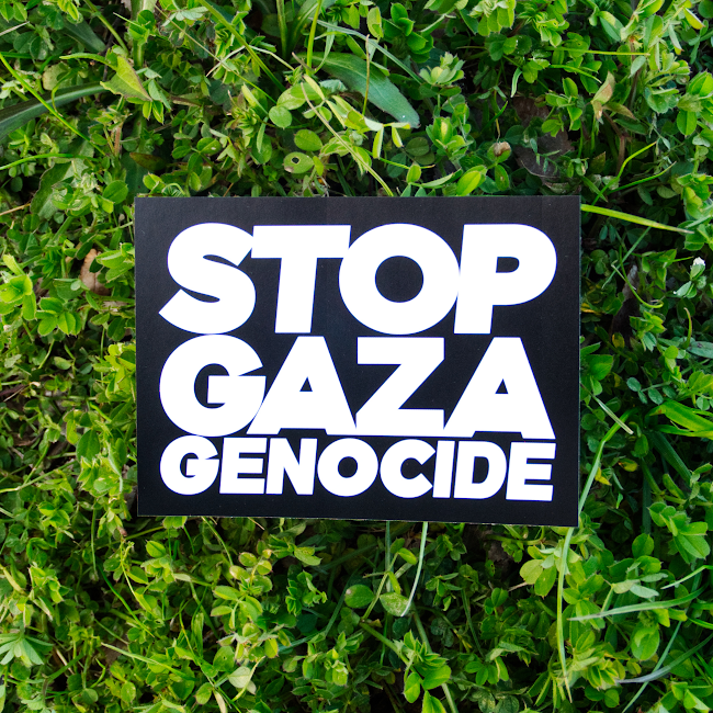 STOP GAZA GENOCIDEと書いてあるステッカー。背景は黒、文字は白い太字。