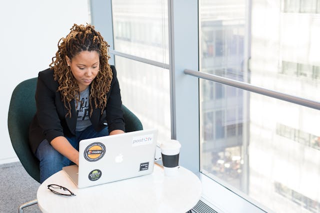 A professional working diligently using her laptop to accomplish her tasks.