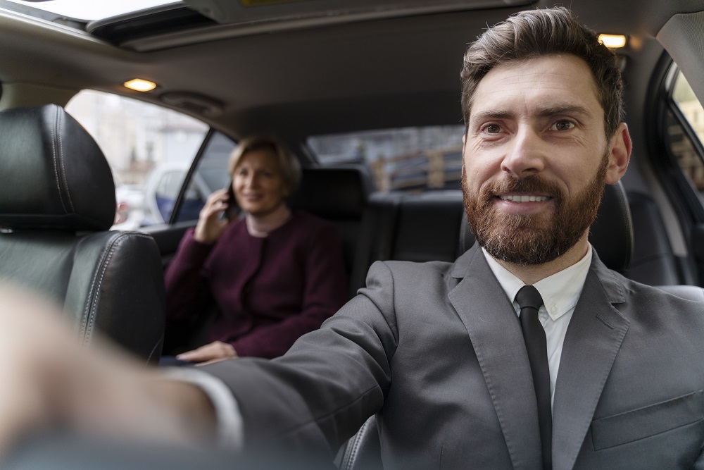 a man in a suit taking a selfie in a car